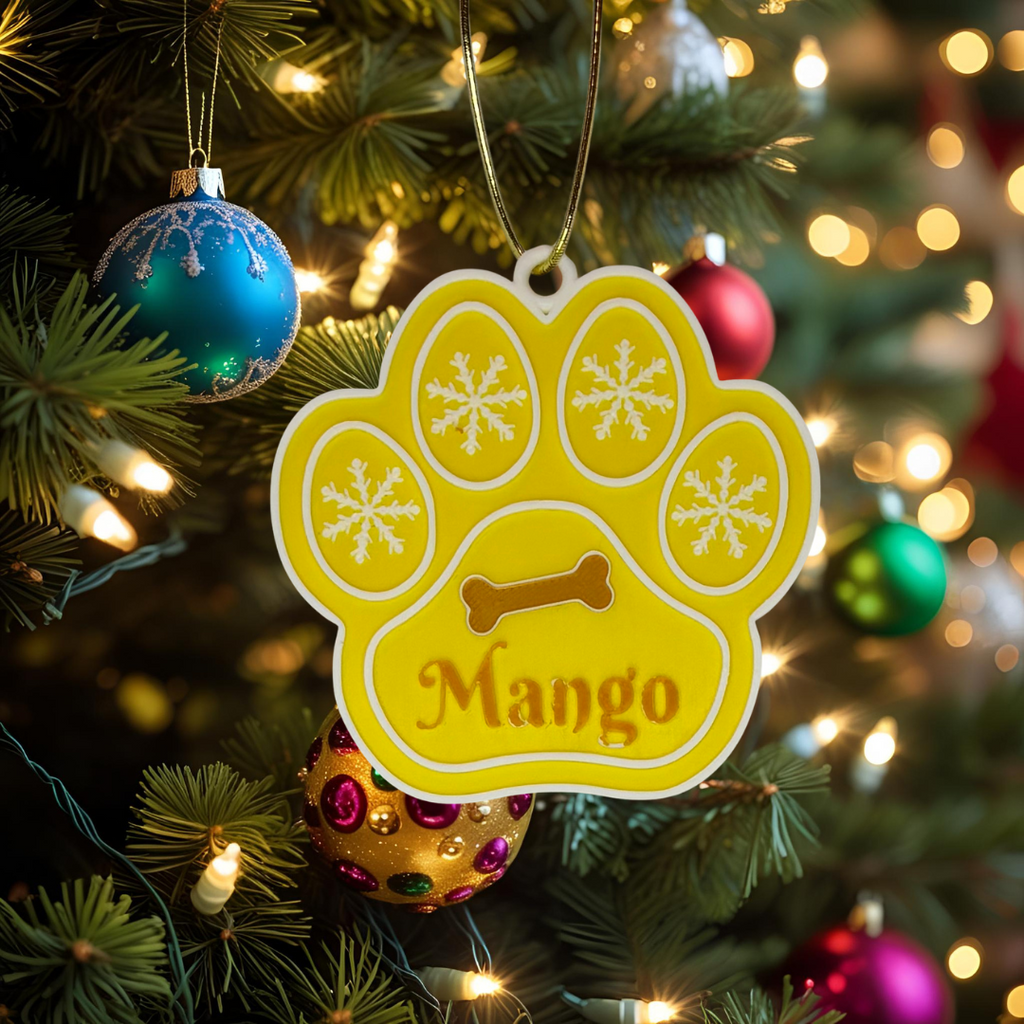 Yellow paw-shaped ornament with 'Mango' on a Christmas tree